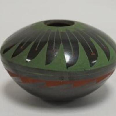 1099	SMALL CARVED BLACK POTTERY VESSEL DECORATED IN RED & GREEN BY MARISELLA TORRES, 2 1/4 IN H 3 1/4 IN DIAMETER 
