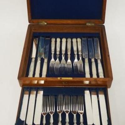 1093	BOX SET 24 PIECE MOTHER OF PEARL HANDLE FISH KNIFE & FORKS IN A MAHOGANY BOX W/ A BRASS MEDALION NOT MONOGRAMMED BOX IS 11 IN X 9...