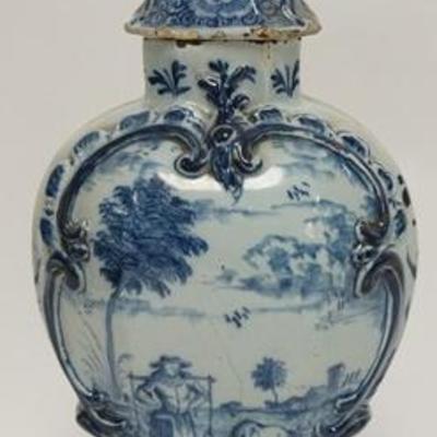 1040	ANTIQUE BLUE & WHITE COVERED URN HAS FIGURAL LION FINIAL, HAND PAINTED W/ A FARM SCENE OF A WOMAN & A COW CARRYING WATER, HAS CHIPS,...