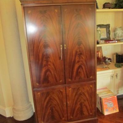 Entertainment center/armoire with a stunning finish and inlaid woods.