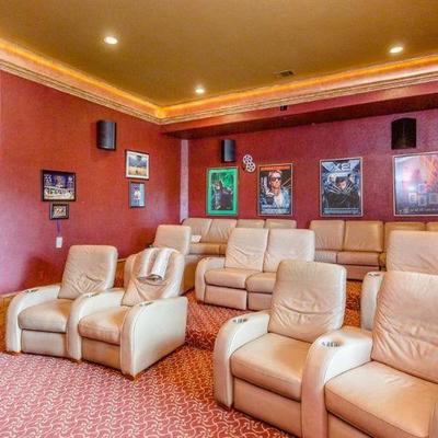 Theater Room with Ivory Leather Theater Chairs.  Also shown are Movie Posters, including Batman, Spiderman, Arnold Schwarzenegger...