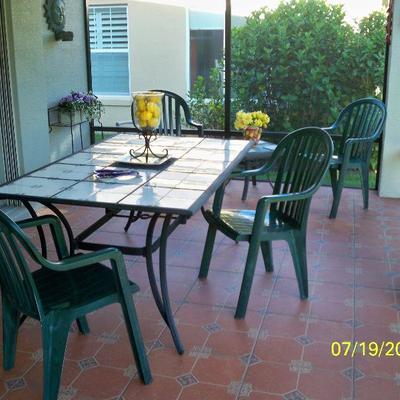 Tile Top Patio Table, 2 of 4 Green Plastic Chairs
