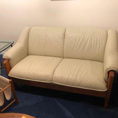 There is a pair of these classic ivory colored leather loveseats  teak  framed  in very good condition nice .