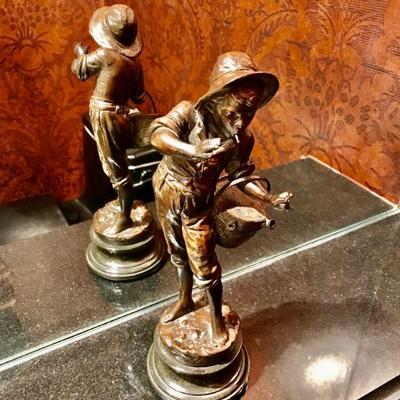 Bronze sculpture of a standing boy on aterrain base, smaoking and carrying a busket, done in a dark brown patina on a marble base...