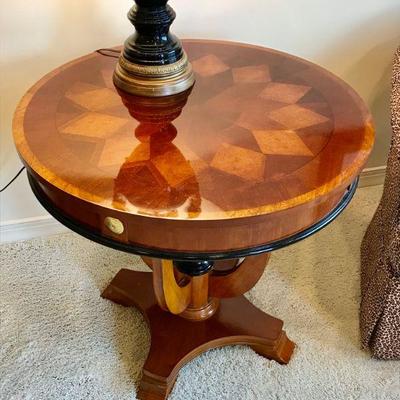 Circular table with band and parquetry inlaid top, raised on tapered suport and four shaped wooden legs, resting on a shaped solid base...