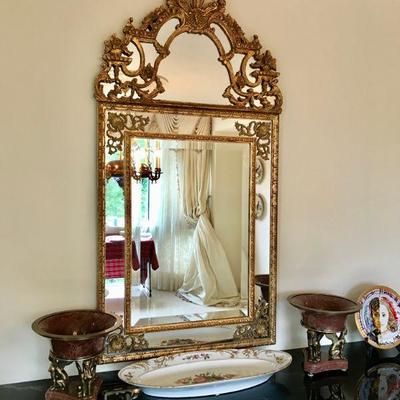 Elaborate gilt framed continental mirror with a 3- feather crest, cyma curve and foliate motif, two bands of pinch-cut framing, base with...