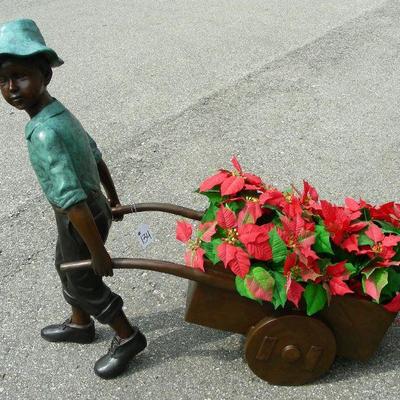 Bronze sculpture of young boy pulling cart