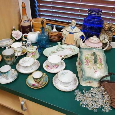562	
China Tea Cups and Saucers, Tea Pot, Desk Clock and More
Also Includes Vintage thimbles, Tequila decanter with leather cover, wood...