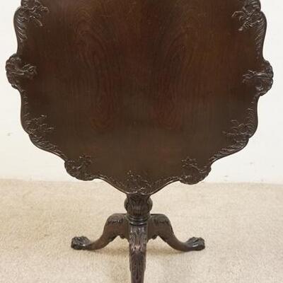 1036	SOLID MAHOGANY TILT TOP TABLE WITH CARVED SCALLOPED EDGE OVER A REEDED COUMN WITH BALL AND CLAW FOOT BASE, 29 1/2 IN WIDE X 28 IN HIGH

