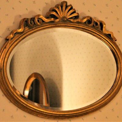 Ornately styled gold frame mirror.