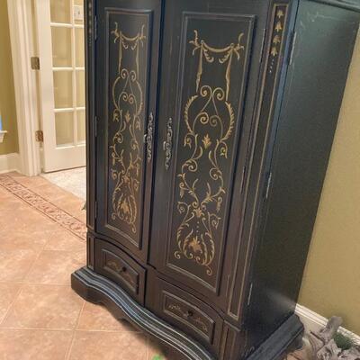 Black armoire with gold piping