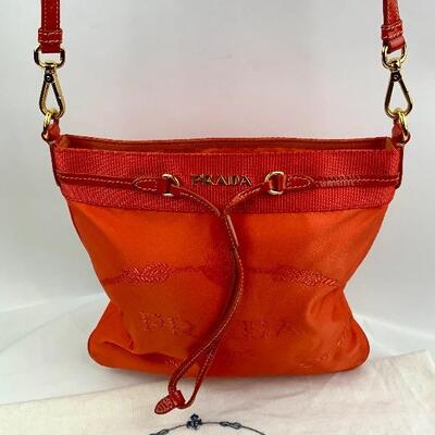 This Prada Orange cross body bag is available for purchase on https://scavengersparadiseestatesales.com    