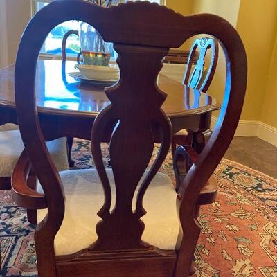 Mahogany dinner table with four side chairs and two arm chairs.