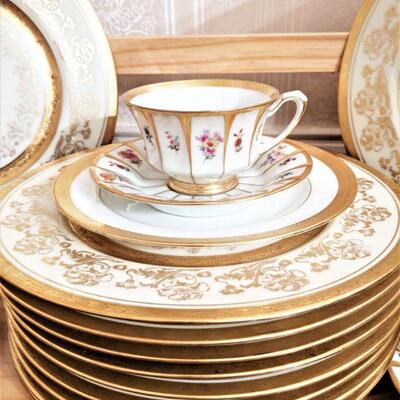 English cup and saucers and closeup of gold rimmed china dinner plates
