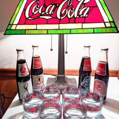Coca Cola stained glass lamp, commemorative bottles (unopened) and drinking glasses.