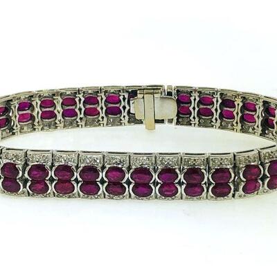 One 18kt white gold ruby & diamond bracelet. The bracelet has a central double row featuring a total of seventy (70), half bezel set,...
