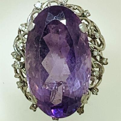 Large 10kt white gold amethyst & diamond cocktail ring. The ring features one (1), four prong set, oval faceted large amethyst set in the...