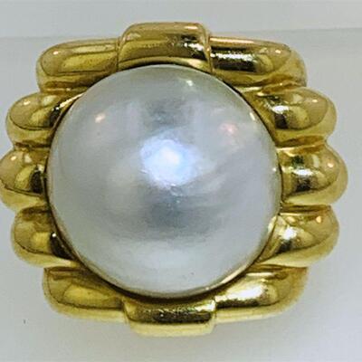 Large 18kt gold mabe pearl fashion ring (size 7.5). The ring features one (1), bezel set, round mabe pearl set in the center of a square...