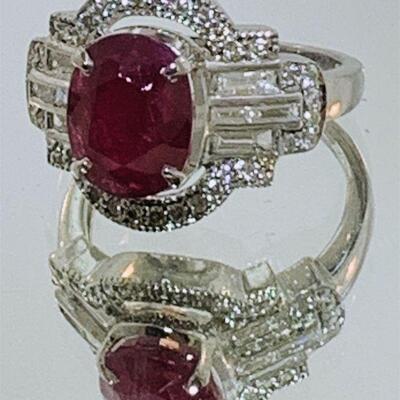 Gorgeous 14kt white gold ruby & diamond cocktail ring. The ring features one (1), four prong set, oval faceted ruby set in the center...