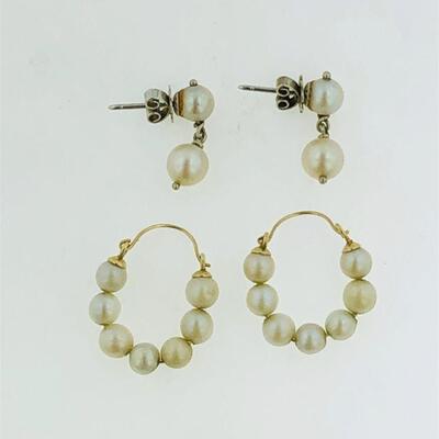 Two pairs of 14kt gold pearl earrings. The first pair has a drop design set with one cultured pearl above another with a slight dangle,...