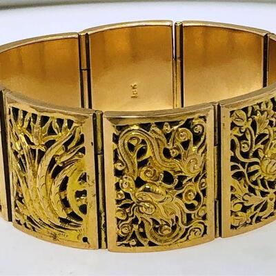 Elaborate 18kt gold link style bracelet. The bracelet is comprised of eight rectangular rounded top links each with a unique scene. The...