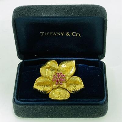 Tiffany & Co. 18kt gold ruby dogwood style brooch in Tiffany box. The brooch features fourteen (14), prong set, round faceted rubies set...