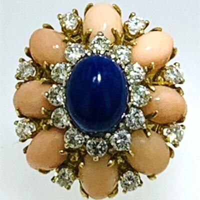 Fabulous 18kt gold cocktail ring featuring lapis, coral & diamonds. The ring features one (1), prong set, oval cabochon lapis set in the...