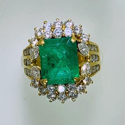 One 22kt gold large emerald & diamond dinner ring (size 5.5). The ring features one (1), four prong set, emerald step cut emerald set in...
