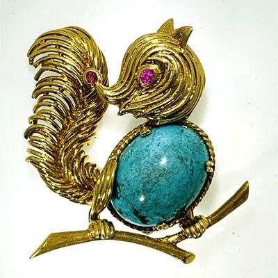 18kt gold turquoise & ruby squirrel brooch perched on a limb. The brooch has a 3-D design with one (1), four prong set, oval cabochon...