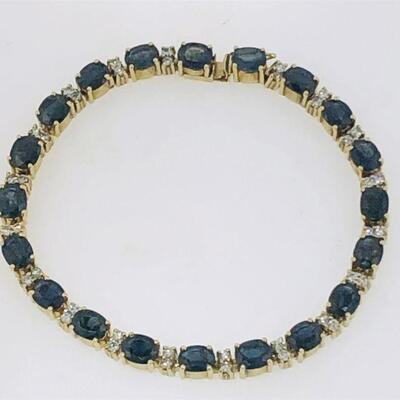 One 14kt gold sapphire & diamond tennis bracelet. The bracelet alternates between twenty(20), four prong set, oval faceted blue sapphires...