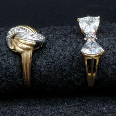 The knot style ring is an approximate size 6 1/2 and the bow shaped ring is approximately a size 7.

 