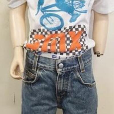 1173	YOUNG BOY MANNEQUIN CLOTHED WITH LEVI JEANS HAVING A RED TAB WITH COPYRIGHT SYMBOL AND VINTAGE BMX TEE SHIRT. MANNEQUIN IS...