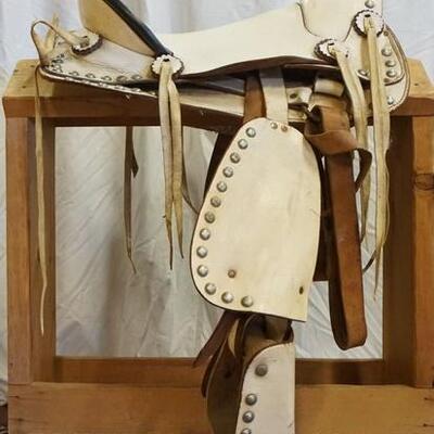 1201	WHITE WESTERN SADDLE WITH METAL HORN MEASURES FROM HORN TO EDGE OF SEAT APPROXIMATELY 15 1/2 IN
