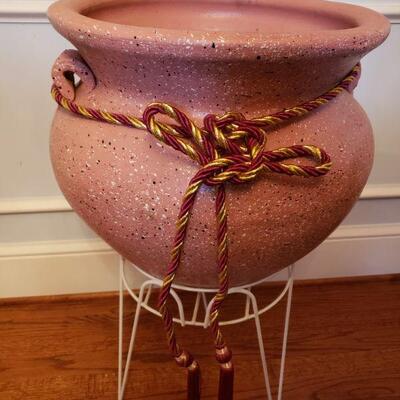 https://ctbids.com/#!/description/share/700612 Beautiful speckled clay pot with red and gold cording on white metal stand. Measures 28