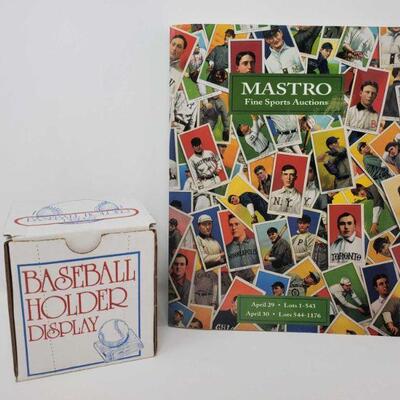 1506:	
Mastro Fine Sports Auctions Catalog and Baseball Holder Display
Mastro Fine Sports Auctions Catalog and Baseball Holder Display
