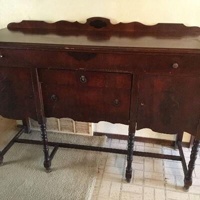 Vintage Buffet. Consists of one large drawer at the top, 2 in the middle, and a door on either side. Measures approximately 59 inches x...