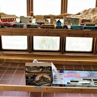 Large train set with lots of trains and accessories.  Board mounted track.