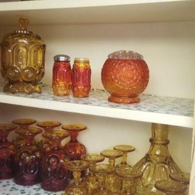 this picture shows two different styles of glass ware, the one is a set of 6 amber and red goblets and the other is a set of eight amber...