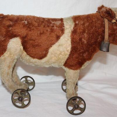 Steiff  Made in Germany Antique Mohair Cow with Leather Collar and Bell Pull Toy on Wheels Circa 1590-1910. (13â€™W x 5â€D x 10â€H)