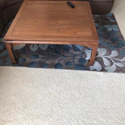 Wood living room table and sable floor rug with blue accents
