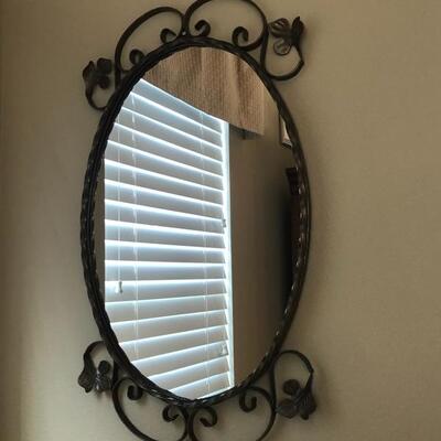 Elegant oval mirror with black trim and floral filigree 