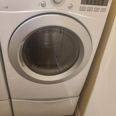 LG front load sensor electric dryer. Pedestal has a partition that can be removed to provide storage for wider things. Measures 27