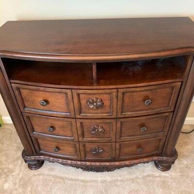 An Ashley Furniture Entertainment center featuring 3 pull out storage drawers and slotted back for cable routing. Adorned with beautiful...