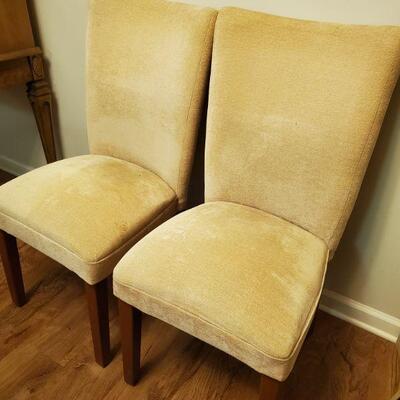 Pair of matching yellow fabric dining chairs with wooden legs. 18x19x39
