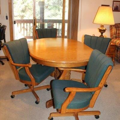Comfortable oak table with four padded chairs and additional leaves.