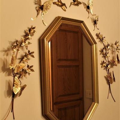 Ornate brass butterflies and mirror.