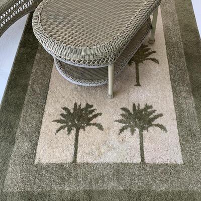 Outdoor wicker loveseat and coffee table pictured with palm print rug. Loveseat measures 55