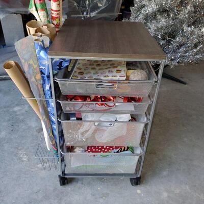 Gift wrap station has 4 mesh wire drawers, a nice wood top and nice rack on the side to store your gift wrap rolls. Cart has wheels to...
