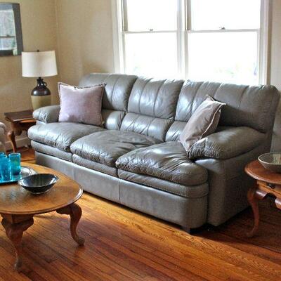 Leather sofa, oval oak side tables with single drawer, oak coffee table, stoneware jug lamp.