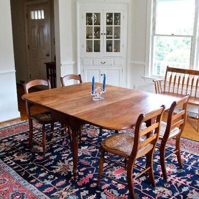 Antique walnut gate leg dining table, set of 4 cane bottom chairs, and Persian style wool & cotton rug.